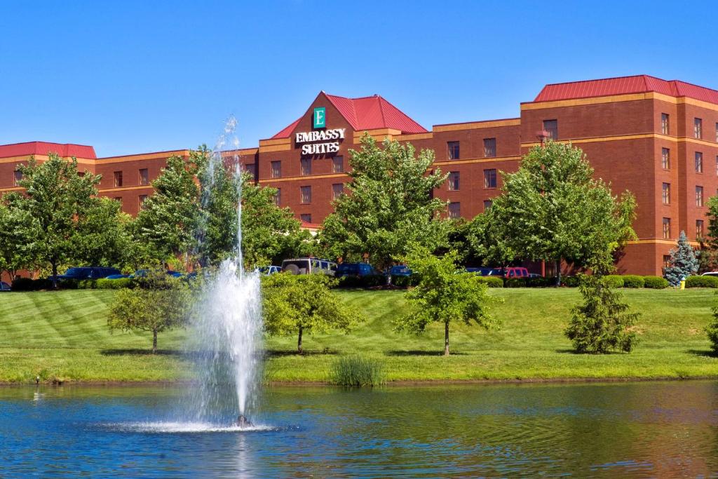 a fountain in the middle of a pond in front of a building at Embassy Suites Lexington in Lexington