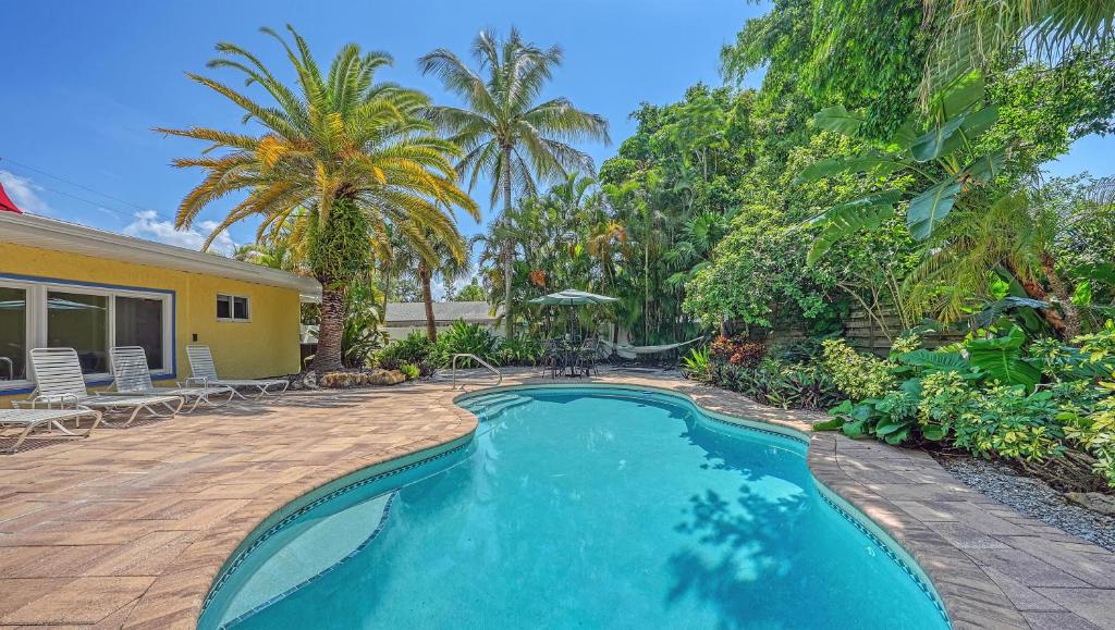 - une piscine en face d'une maison avec des palmiers dans l'établissement Crescent Cottage - 1034, à Siesta Key