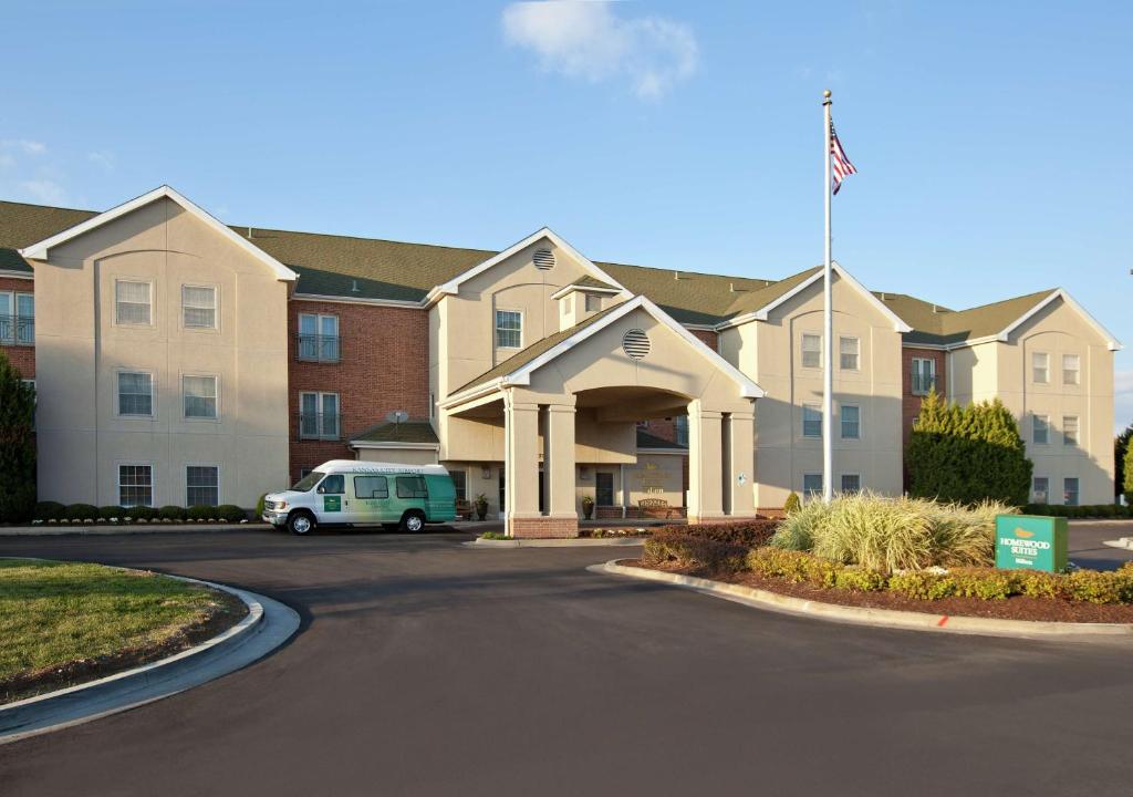 a apartment building with a van parked in front of it at Homewood Suites by Hilton Kansas City Airport in Kansas City