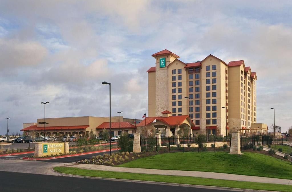 ein großes Gebäude mit einem grünen Kreuz darüber in der Unterkunft Embassy Suites by Hilton San Marcos Hotel Conference Center in San Marcos
