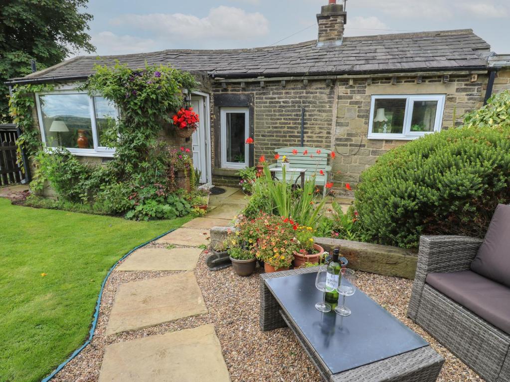 a garden with a table and a house at Prospect Cottage in Sowerby Bridge
