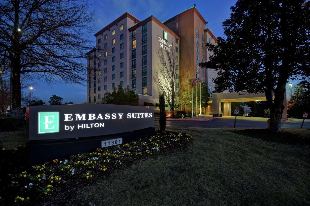 un cartello per le suite dell'ambasciata di Hilton di fronte a un edificio di Embassy Suites Little Rock a Little Rock
