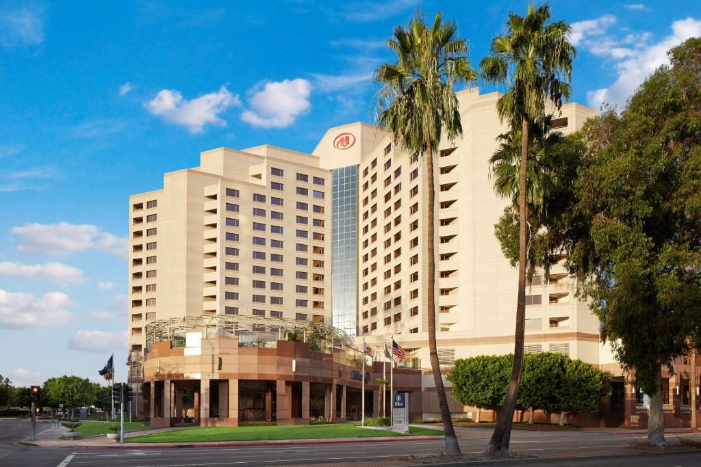 a large building with palm trees in front of it at Hilton Long Beach Hotel in Long Beach