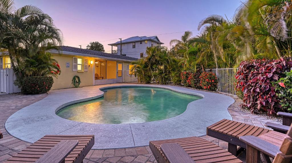 ein Pool mit zwei Bänken und ein Haus in der Unterkunft Casita Sun Star - 1135 in Siesta Key