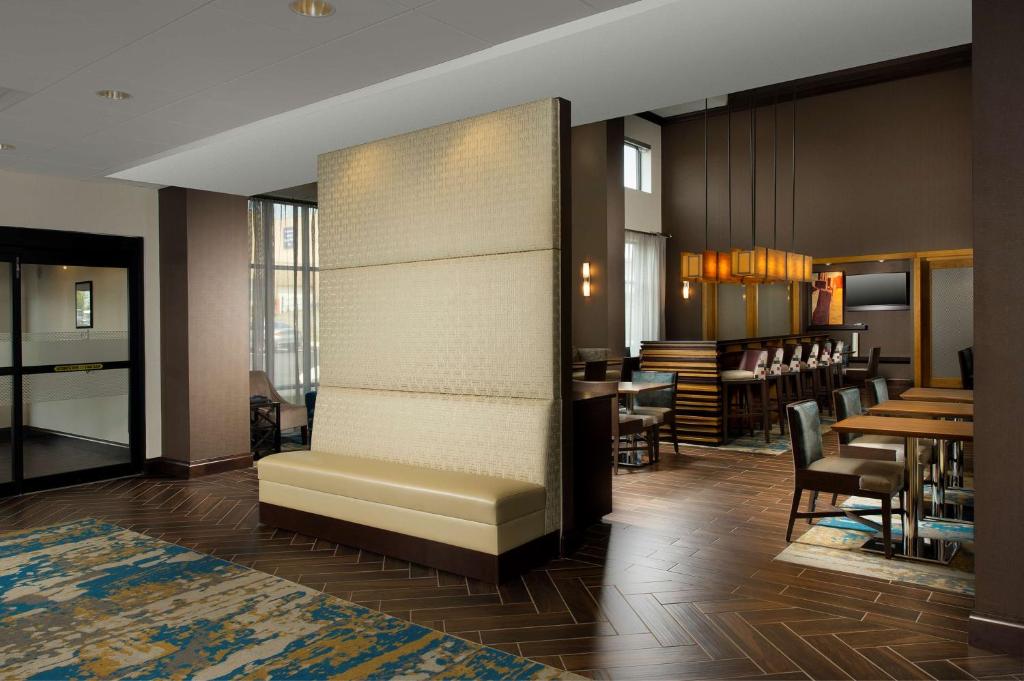 a lobby with a bench and tables and a restaurant at Hampton Inn & Suites Baltimore North/Timonium, MD in Timonium