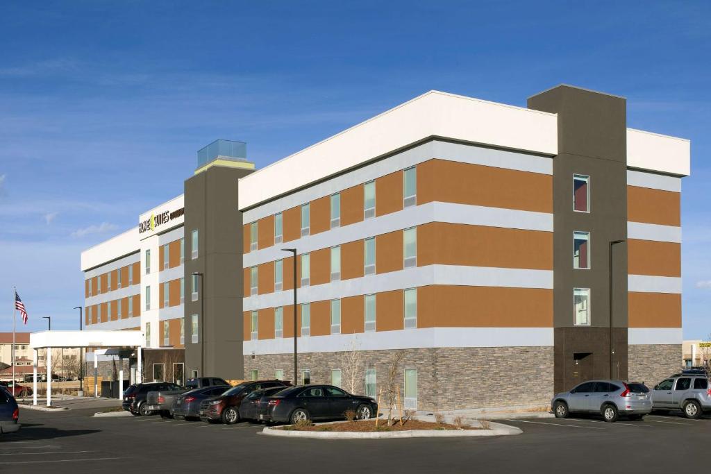 a large building with cars parked in a parking lot at Home2 Suites by Hilton Denver International Airport in Denver