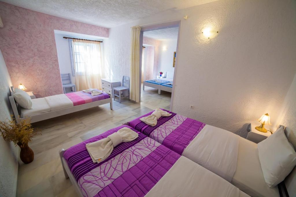 a bedroom with a purple and white bed in a room at St.George Valsamitis in Katapola