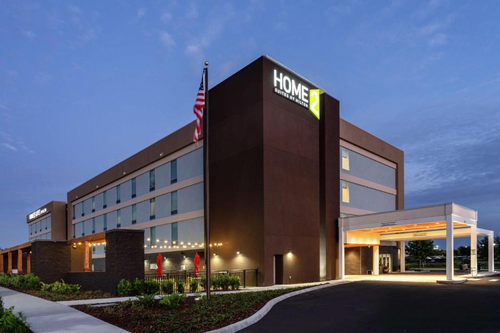 a hotel building with a sign on the front of it at Home2 Suites By Hilton Clermont in Clermont