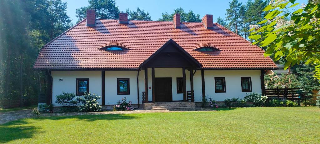 une petite maison blanche avec un toit rouge dans l'établissement Dworek Zaporów, 