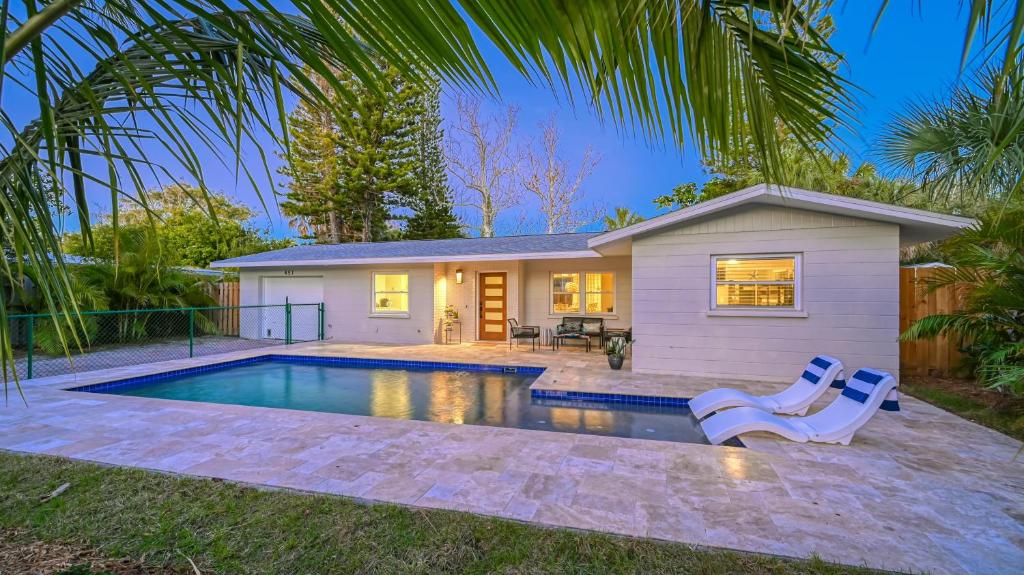 uma casa com piscina e uma casa em Beach Walk Cottage - 451 em Siesta Key