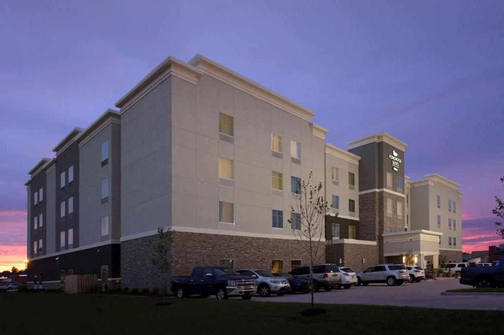 un gran edificio con coches estacionados en un estacionamiento en Homewood Suites by Hilton Metairie New Orleans en Metairie