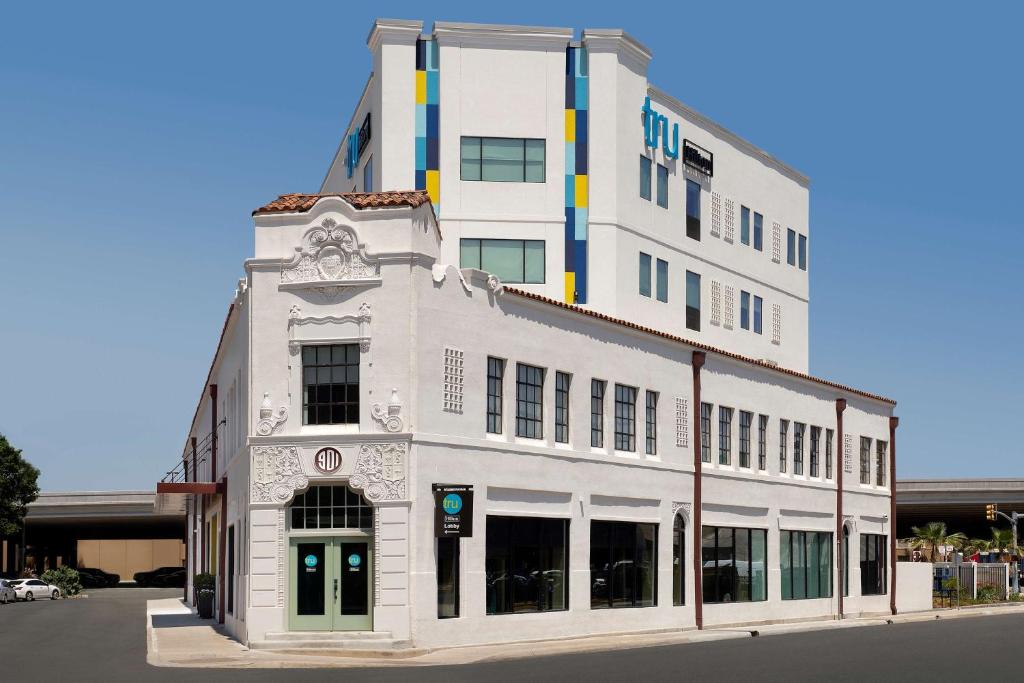 a white building sitting on the side of a street at Tru By Hilton San Antonio Downtown Riverwalk in San Antonio