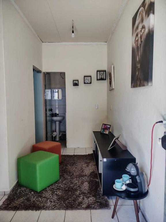 a living room with a green chair and a desk at Studio 2 próximo ao Centro in Palmas