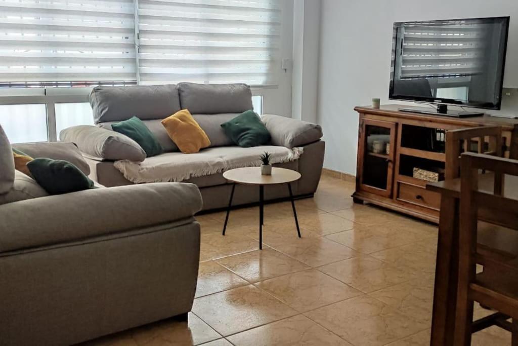 a living room with a couch and a tv at Acogedor piso cerca de la playa in Puerto de Sagunto