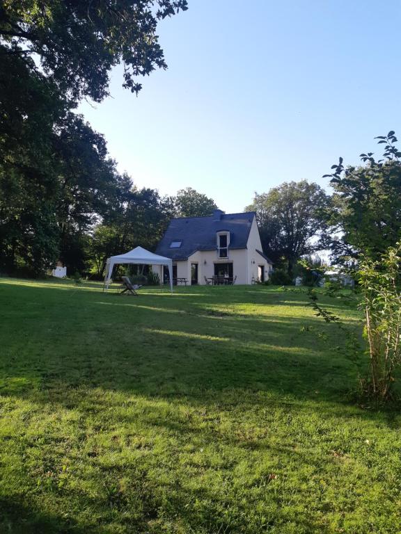 una casa bianca con gazebo in un campo di Chambre d'hôte cosy & zen a Saint-Jean-la-Poterie