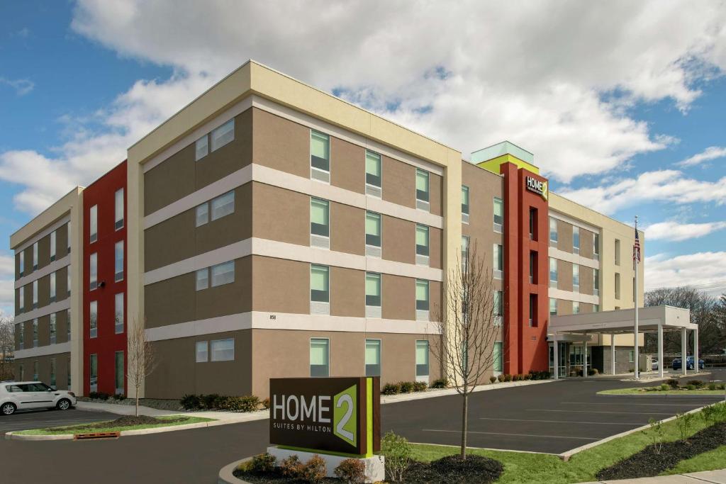 un edificio con un signo de mejora del hogar delante de él en Home2 Suites By Hilton Edison, en Edison