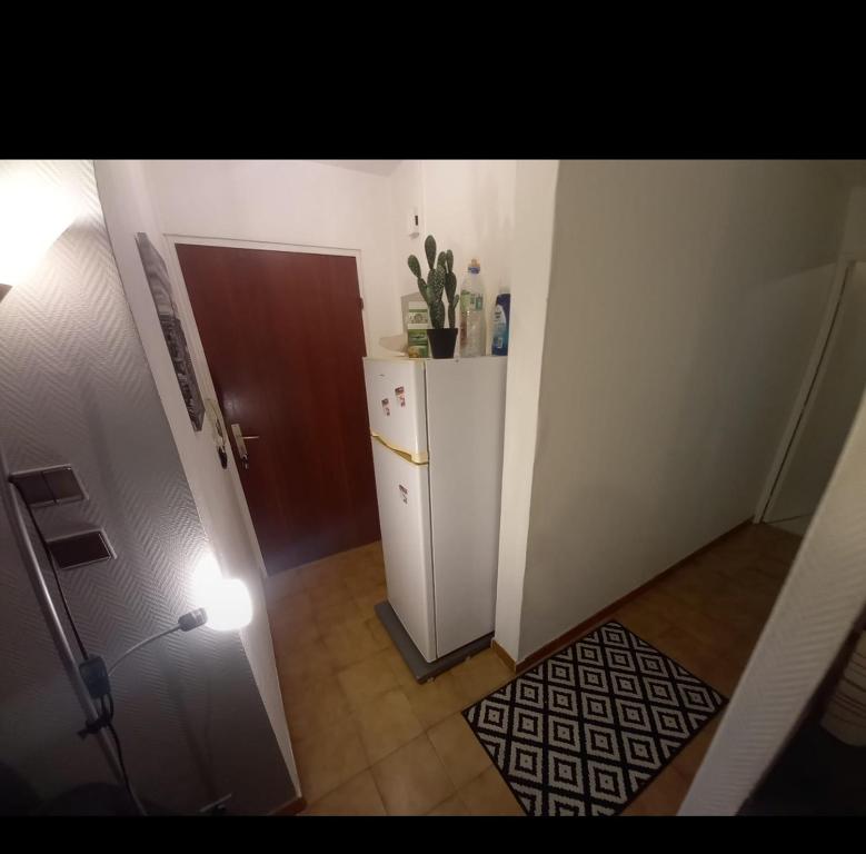 un corridoio con un piccolo frigorifero in camera di idéal pour vacances et affaires a Perpignano