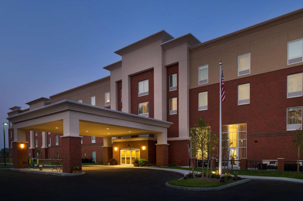 ein Gebäude mit einer Flagge davor in der Unterkunft Hampton Inn & Suites Syracuse/Carrier Circle in East Syracuse