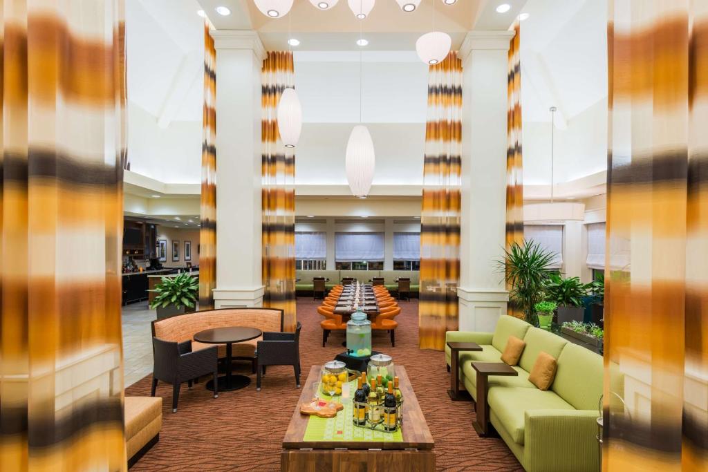 um lobby com sofás e uma mesa com comida em Hilton Garden Inn Wayne em Wayne