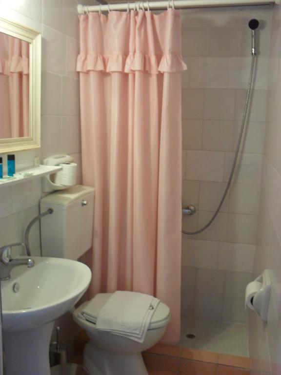 a bathroom with a pink shower curtain and a toilet at La Santre Villa in Amoudara Herakliou