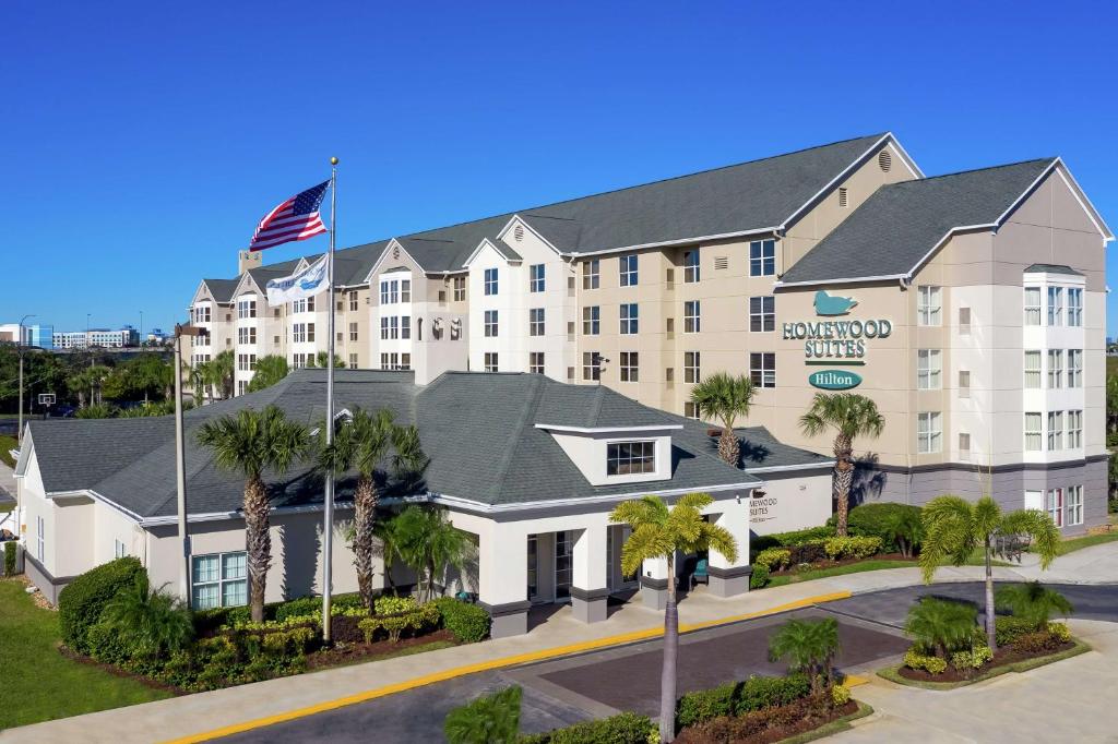 an exterior view of a hotel with palm trees at Homewood Suites by Hilton Orlando-Nearest to Universal Studios in Orlando