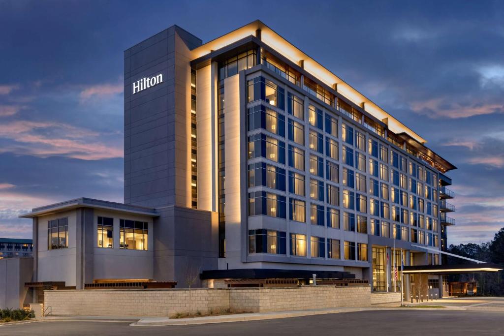 un edificio de hotel con un cartel en el costado en Hilton Alpharetta Atlanta, en Alpharetta