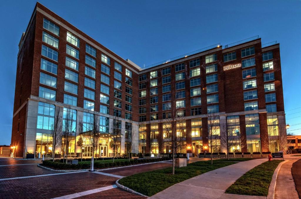 a large brick building with lights on at Hilton Nashville Green Hills in Nashville