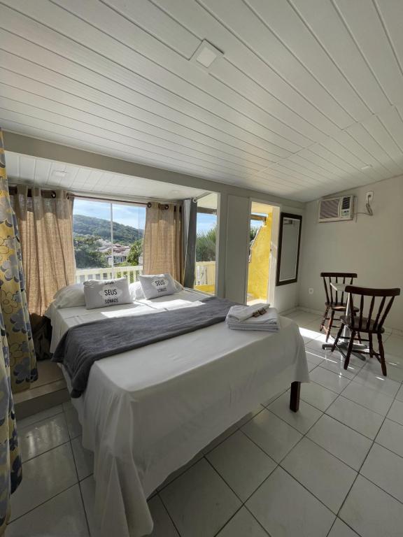 a bedroom with a large bed in a room with windows at SOL in Búzios
