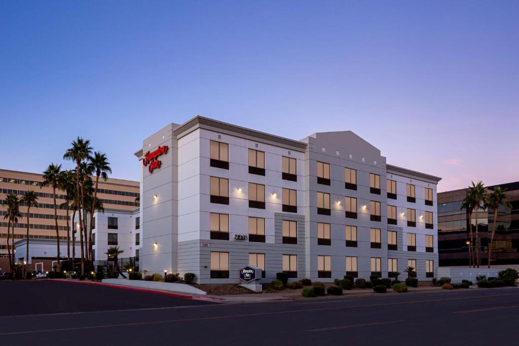 un grand bâtiment blanc avec un arc rouge sur lui dans l'établissement Hampton Inn Phoenix - Biltmore, à Phoenix