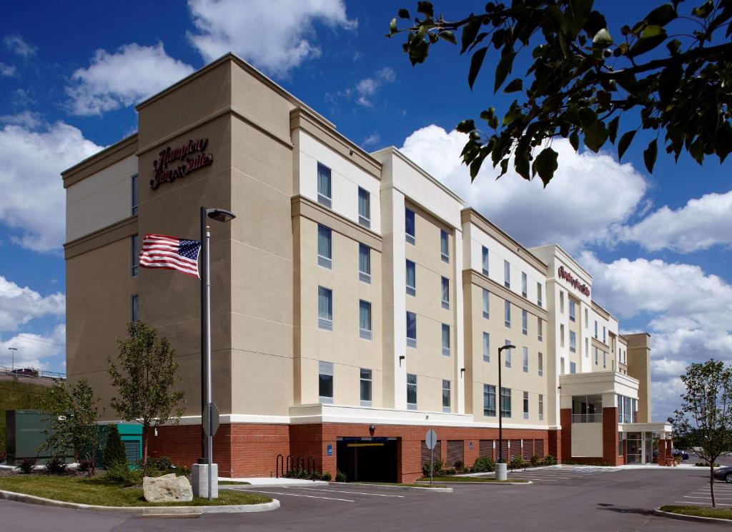 an office building with an american flag in front of it at Hampton Inn & Suites Pittsburgh Airport South/Settlers Ridge in Robinson Township