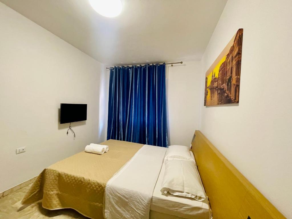 a small bedroom with a bed and a blue curtain at Dream Apartment in Mestre