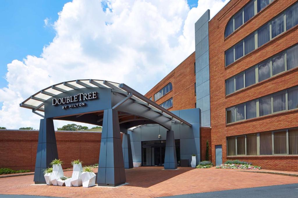 Doubletree By Hilton Atlanta Perimeter Dunwoody في أتلانتا: مبنى عليه لافته مكتوب عليها جامعة الدوشين