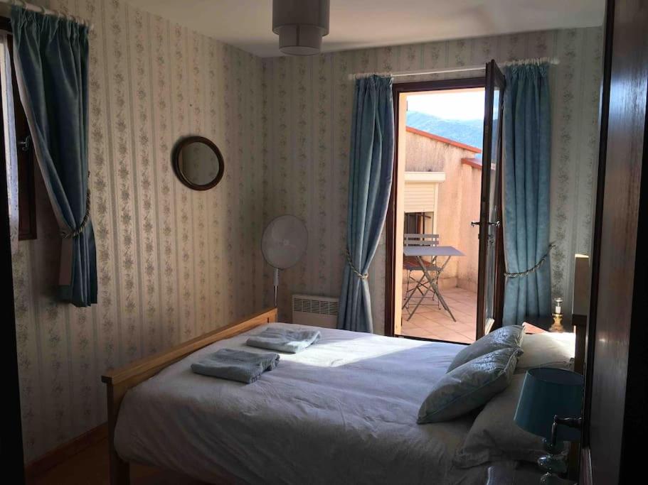 ein Schlafzimmer mit einem Bett und ein Fenster mit einer Terrasse in der Unterkunft Luxury villa with amazing views in 3200m2 in Laroque-des-Albères
