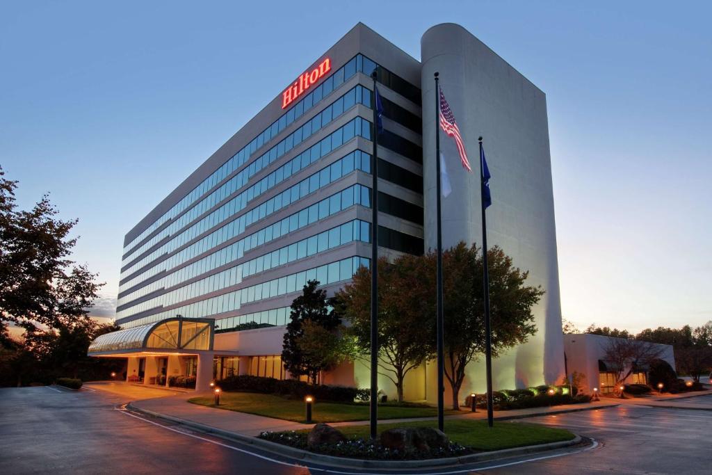 un edificio con una bandera americana delante de él en Hilton Greenville, en Greenville