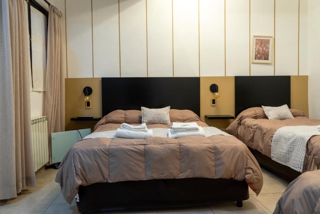 1 dormitorio con 2 camas y toallas. en Hotel del Tren en Salta