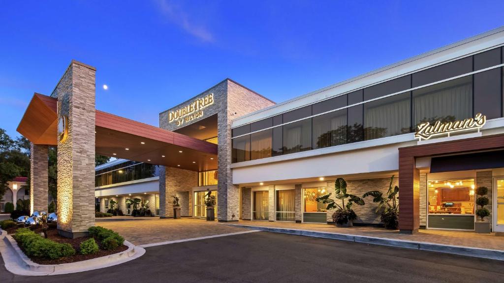 un hotel con aparcamiento frente a un edificio en The Kingsley Bloomfield Hills - a DoubleTree by Hilton, en Bloomfield Hills