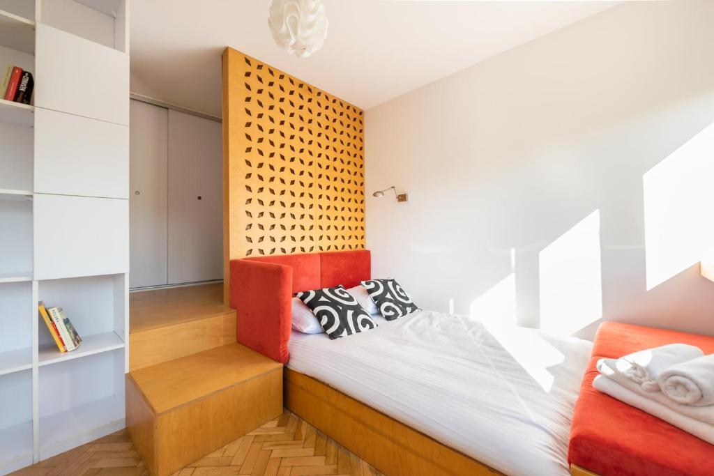 a bedroom with a bed with a wooden headboard at Spiska Standard Studio in Warsaw