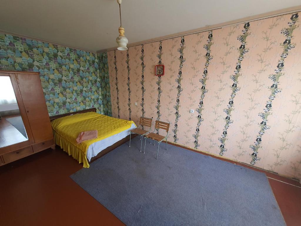 a bedroom with a bed and a wall with wallpaper at Квартира на Бульварі Вечірньому in Kryvyi Rih