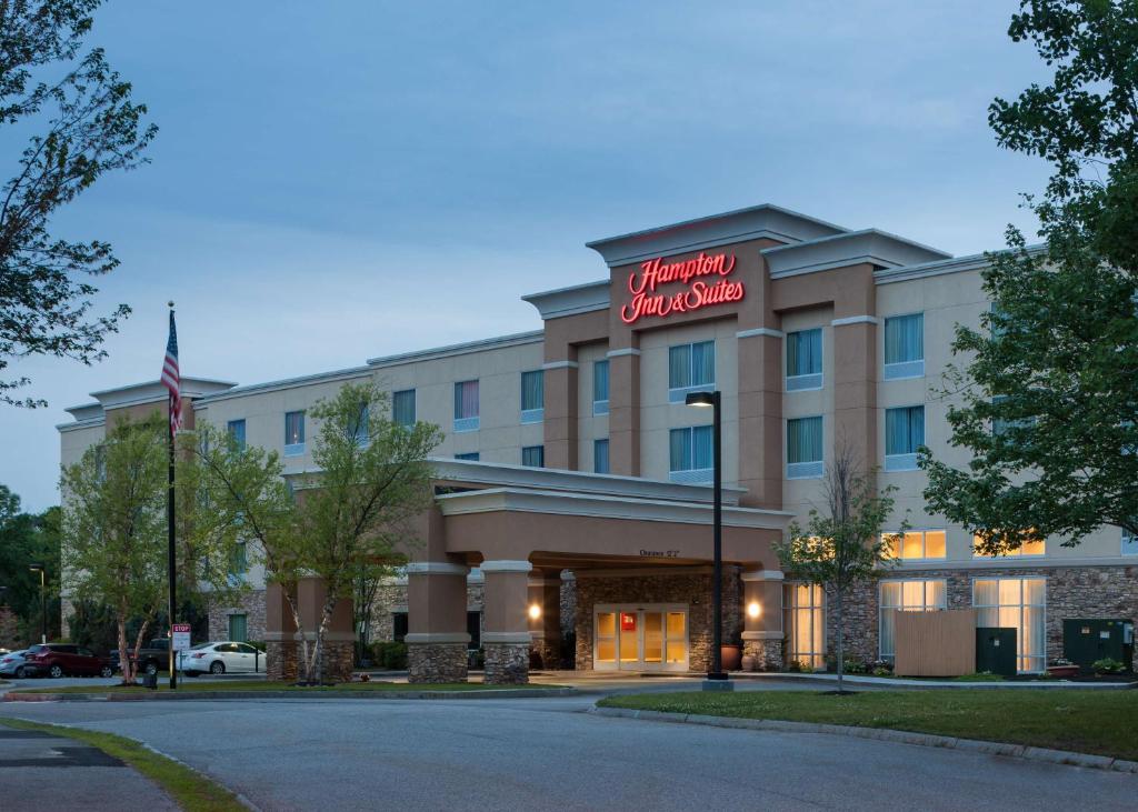 a hotel building with a sign on the front of it at Hampton Inn & Suites Westford-Chelmsford in Westford