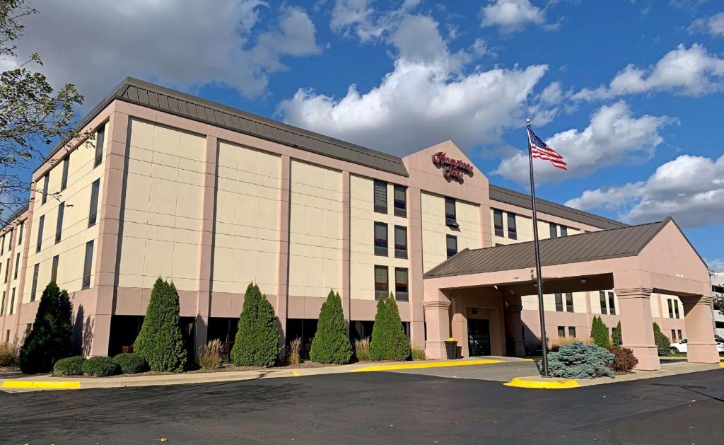 UrbanaにあるHampton Inn Champaign/Urbanaの前面にアメリカ旗を掲げた建物