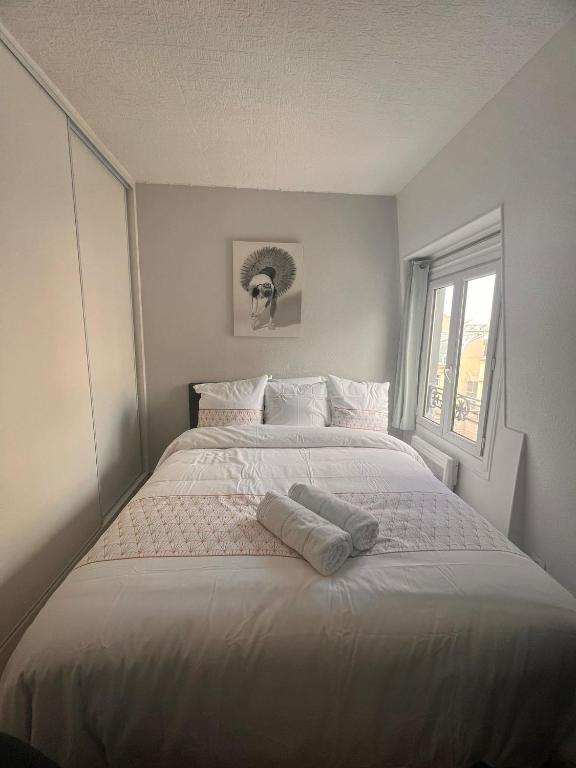 une chambre avec un grand lit blanc avec une fenêtre dans l'établissement Studio Arc de triomphe - HALA PARIS, à Paris
