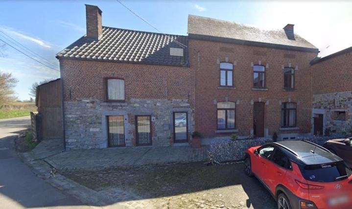 a red car parked in front of a brick house at Au Randonneur - B&B in Thuin