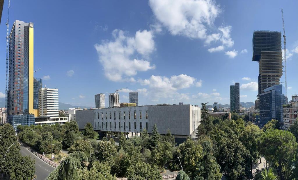 uitzicht op een stad met hoge gebouwen en bomen bij Apartment in Skanderbeg Square - Tirana Center 2 in Tirana