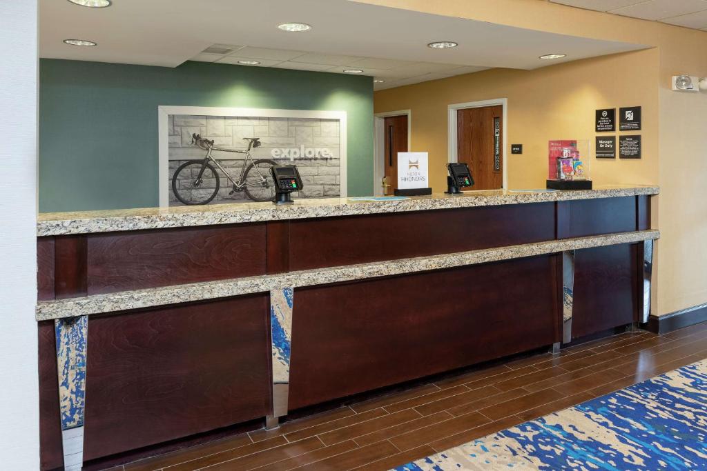 a bar in a hospital lobby with a bike on the wall at Hampton Inn East Lansing in East Lansing