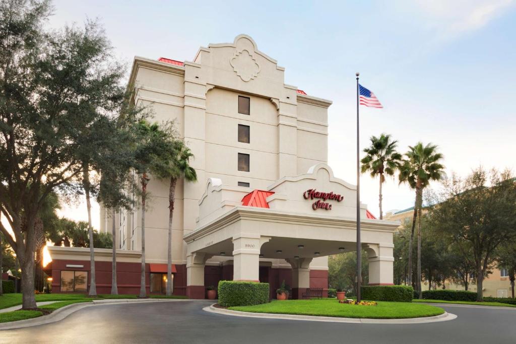 Um edifício com uma bandeira americana à frente. em Hampton Inn Orlando-Convention Center International Drive Area em Orlando