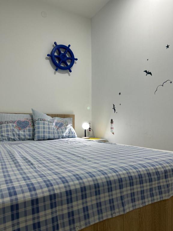 a bedroom with a bed with a blue and white checked blanket at Adam's Apartment 1 in Kladovo