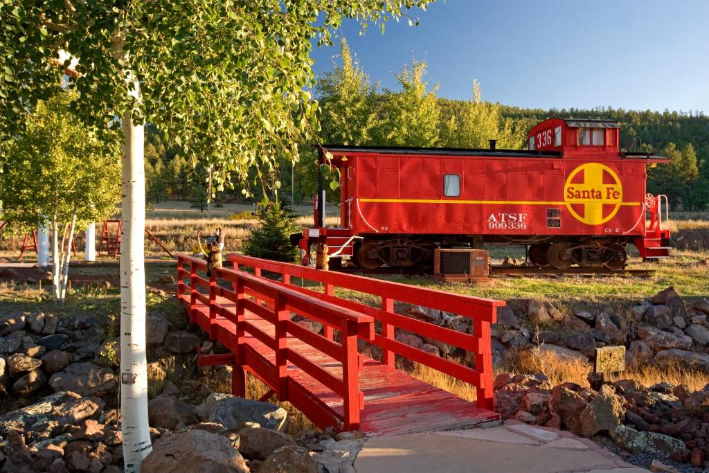a red train car sitting on top of a wooden platform at The Canyon Motel & RV Park in Williams