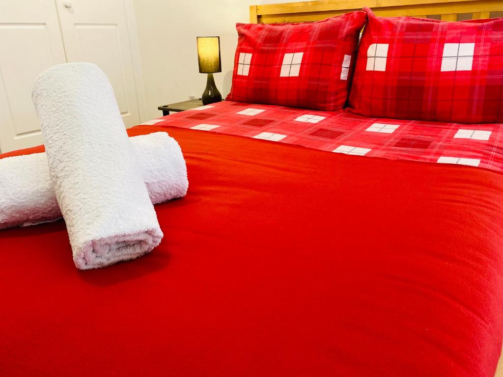 a red bed with red pillows and red sheets at Central London Mansion House in London