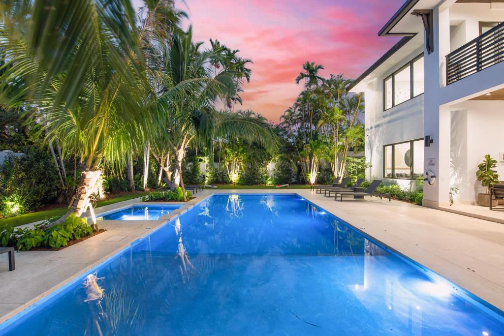 - une piscine dans l'arrière-cour d'une maison avec des palmiers dans l'établissement Villa in Coral Gables with Pool Jacuzzi Game Room, à Miami