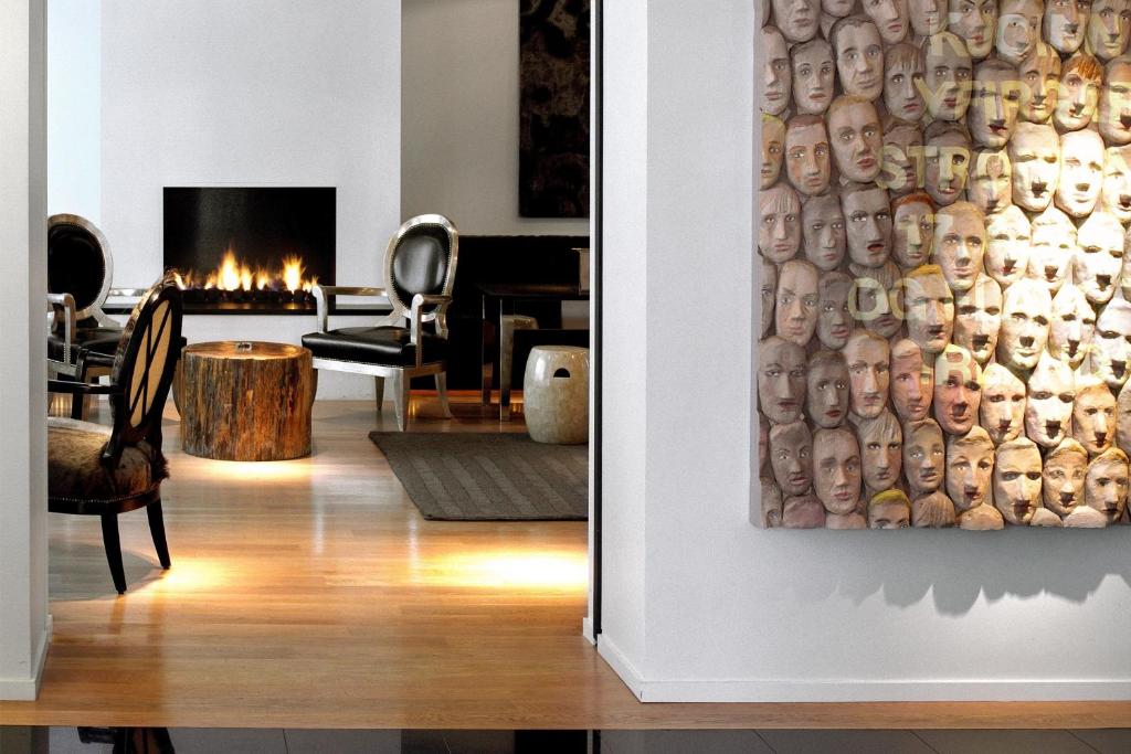 a living room with a painting of faces on the wall at 101 Hotel, a Member of Design Hotels in Reykjavík